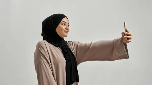 Felice giovane donna araba in hijab prendendo selfie — Foto Stock