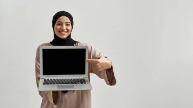 Dizüstü bilgisayar ekranı gösteren mutlu genç Arap kadın.