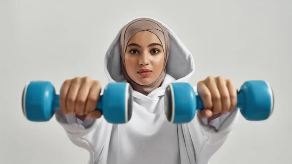 Fiatal arab nő hidzsábi kezében súlyzók — Stock Fotó