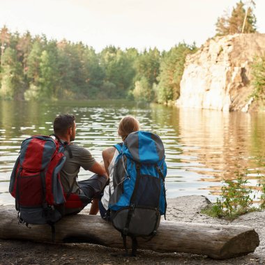 Kafkasyalı genç bir çiftin kütüğün üzerinde oturuşunun arkası.