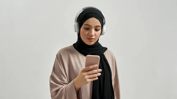 Attractive young arabian woman in hijab and headphones — Foto Stock