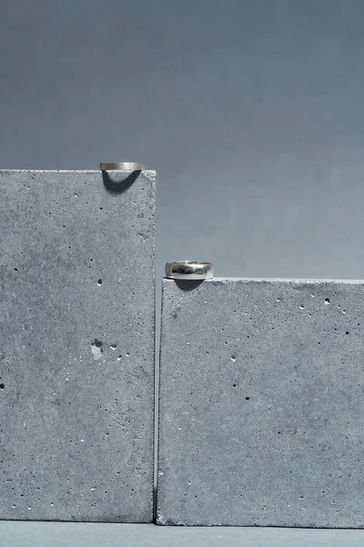 Studio shot of silver rings on concrete elements isolated over gray background — 스톡 사진