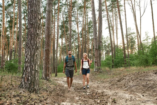 Happy young caucasian couple trekking in summer wood — Stok fotoğraf