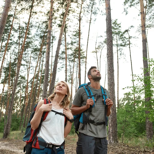 Happy young caucasian couple with tourist backpacks