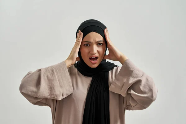 Депресивна молода арабська жінка тримає руки біля голови — стокове фото