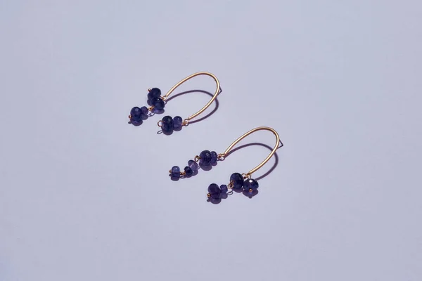 Stylish asymmetrical handmade earrings with purple beads isolated over light background — Fotografia de Stock