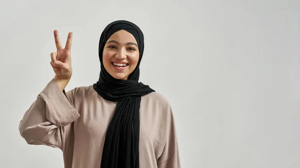 Happy young arabian woman in hijab showing victory sign — Foto Stock