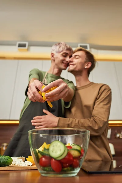 Selective focus on fresh salad cooked by hugging couple — Foto Stock