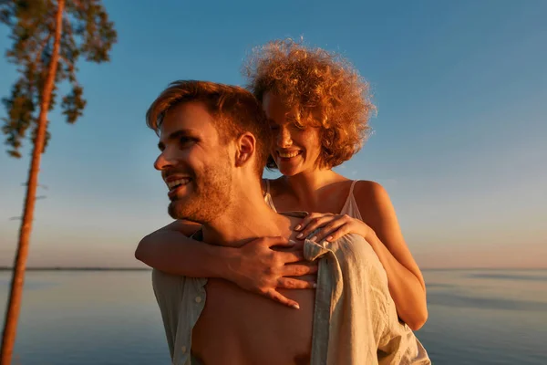 Portrait of young woman sitting on back of boyfriend — Fotografia de Stock