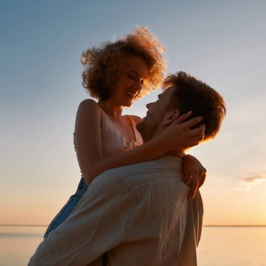 Portrait of happy young caucasian man raising girlfriend