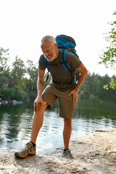 Tired middle aged caucasian man with aching knee — Fotografia de Stock