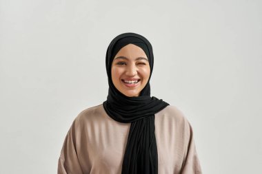 Portrait of cheerful young arabic girl in hijab smiling
