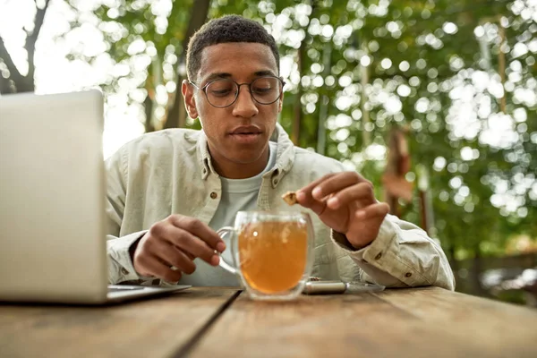 Frontansicht eines jungen schwarzen Mannes, der sich eine Tasse Tee macht — Stockfoto