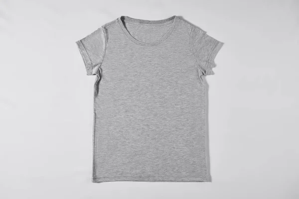 Gray T-shirt lying on a light background — Zdjęcie stockowe