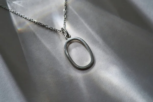 Neck chain with oval pendant on gray background — Fotografia de Stock