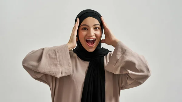 Емоційна молода арабська жінка тримає руки біля голови — стокове фото