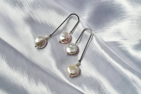 Shiny sterling silver dangle earrings with natural pearls