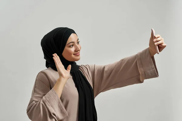 Весела молода арабська жінка в хіджабі приймає селфі — стокове фото