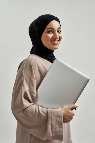 Modern dizüstü bilgisayarı olan neşeli genç bir Arap kadın. — Stok fotoğraf