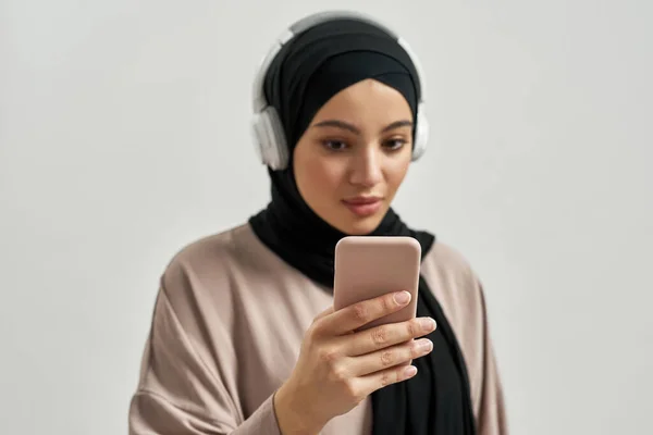 Carino giovane donna araba in hijab e cuffie — Foto Stock