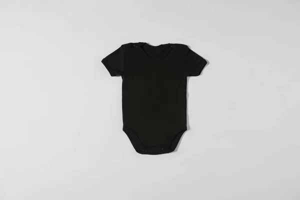 T-shirt preta deitada sobre um fundo branco — Fotografia de Stock