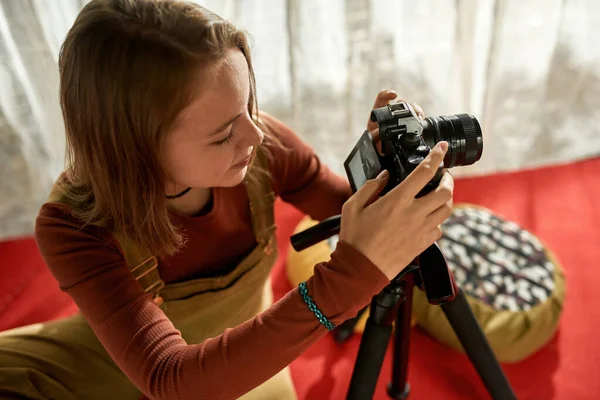 Vista superior de uma menina com câmera sentada no tapete vermelho — Fotografia de Stock