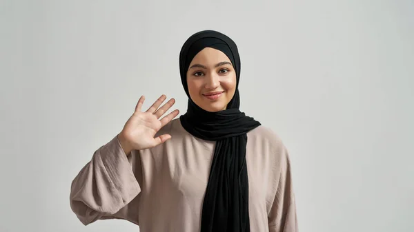 Щаслива молода арабська жінка в хіджабі махає рукою — стокове фото