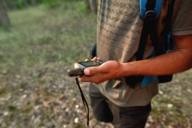 Ormanda dikilirken GPS kullanarak genç erkek turistlerin yerlerini belirlemek için yakın plan.