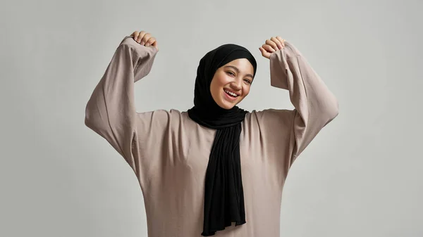 Χαρούμενη νεαρή Αραβίδα που χαμογελάει πλατιά και σηκώνει τα χέρια — Φωτογραφία Αρχείου