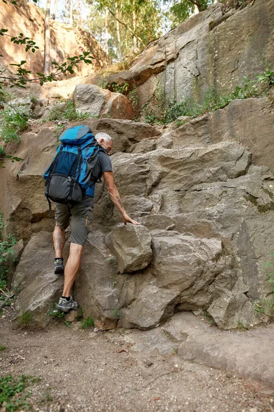 Vue arrière de caucasien d'âge moyen escalade rochers — Photo