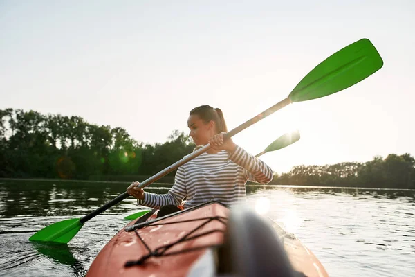 一个活跃的年轻女人喜欢夏天和男朋友在湖里划船 — 图库照片
