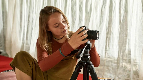 Jovem mulher sentada em uma tenda com câmera — Fotografia de Stock