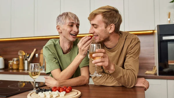 Omosessuale coppia maschile mangiare spuntini e bere vino — Foto Stock