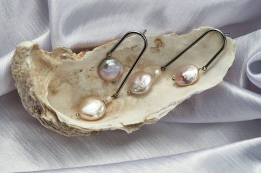 Stüdyo çekiminde kabuğun içinde gümüş küpeler.