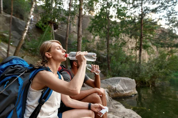 Jovem casal caucasiano de turistas água potável — Fotografia de Stock