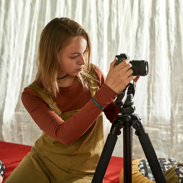 Jovem mulher preparando sua câmera para o trabalho — Fotografia de Stock