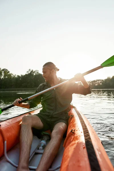 Actieve blanke jongeman kajakken in een meer op een zomerse dag — Stockfoto