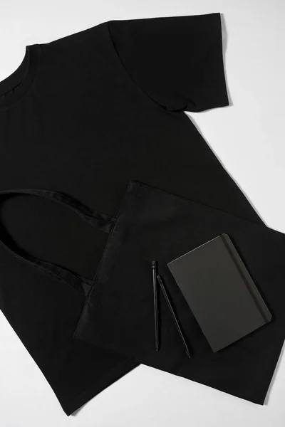 T-shirt preta e tesouro deitado no estúdio — Fotografia de Stock