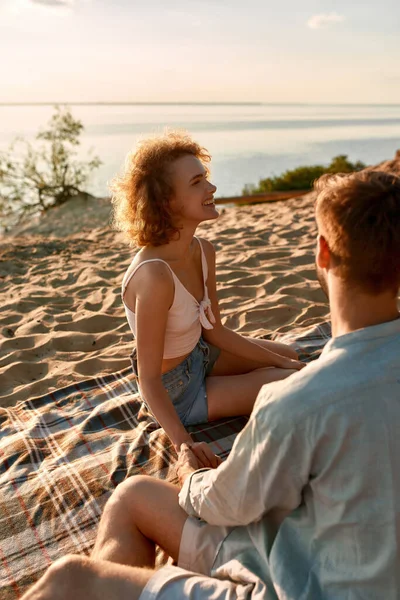 Feliz joven pareja caucásica cogida de la mano en la playa — Foto de Stock