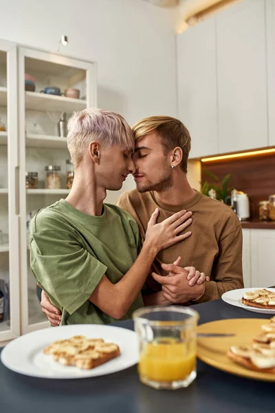 Omosessuale giovani maschi gli amanti abbracci a cucina tavolo — Foto Stock
