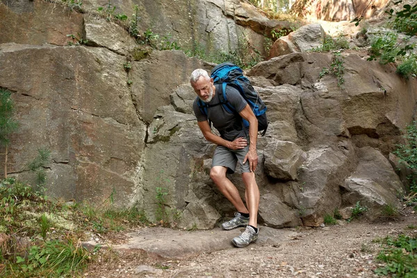 Kaukasischer Mann mittleren Alters beim Trekking am Bein verletzt — Stockfoto