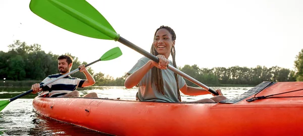 Gelukkig jong paar vrienden hebben plezier op kajak op een late zomermiddag — Stockfoto