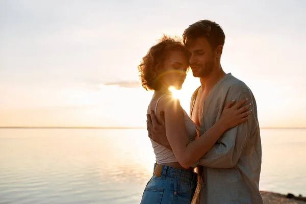 Sensual young caucasian couple embracing at sunset — Stock Photo, Image