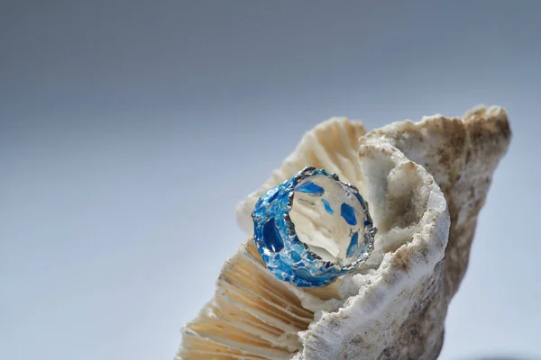 Schöner Ring aus Silber mit blauem Emaille oben auf Muschel isoliert über Gradienten Hintergrund angeordnet — Stockfoto