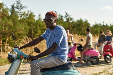 Retro scooterlı yakışıklı Afrikalı Amerikalı adam.