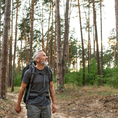 Büyük sırt çantalı mutlu bir beyaz adam.