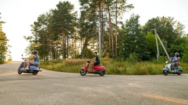 Yol boyunca eski mobiletlere binen çok ırklı genç insanlar.