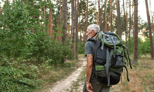 Mature caucasian man with large backpack trekking — Stock Photo, Image
