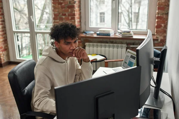 PCとラップトップを使用してオンラインで取引若い男の高い角度ビュー,現代のリビングルームのオフィスに家に座って — ストック写真