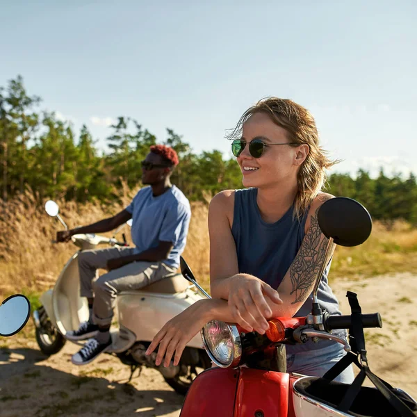 Jóvenes amigos multirraciales sentados en motocicletas scooter — Foto de Stock